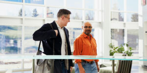 Two men walking and making connections